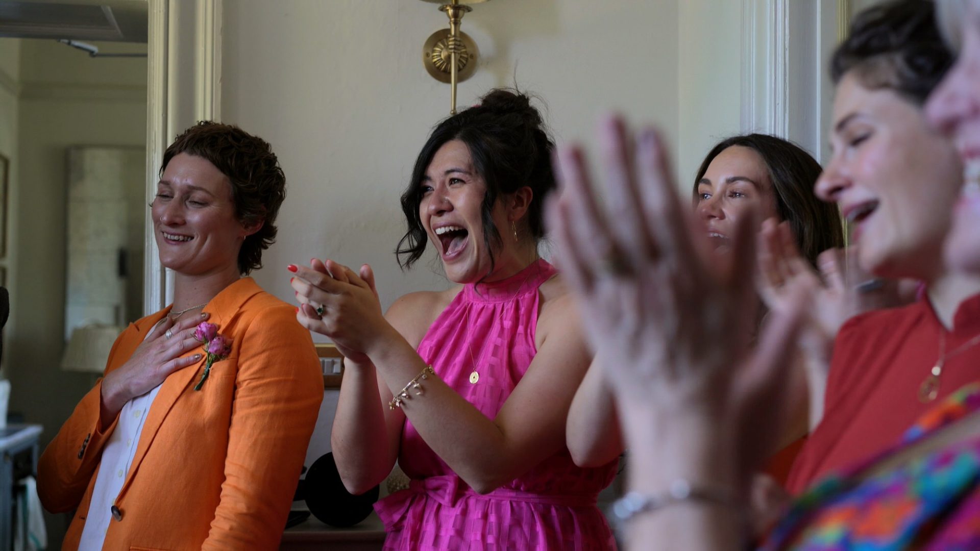 excited bridesmaids wearing bright coloured dresses react to the brides first look at Wyresdale Park