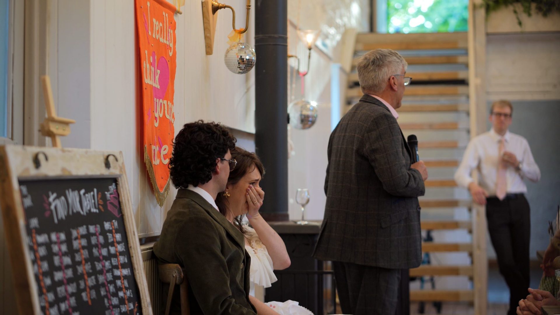 a video still of an emotional bride during her dads speech
