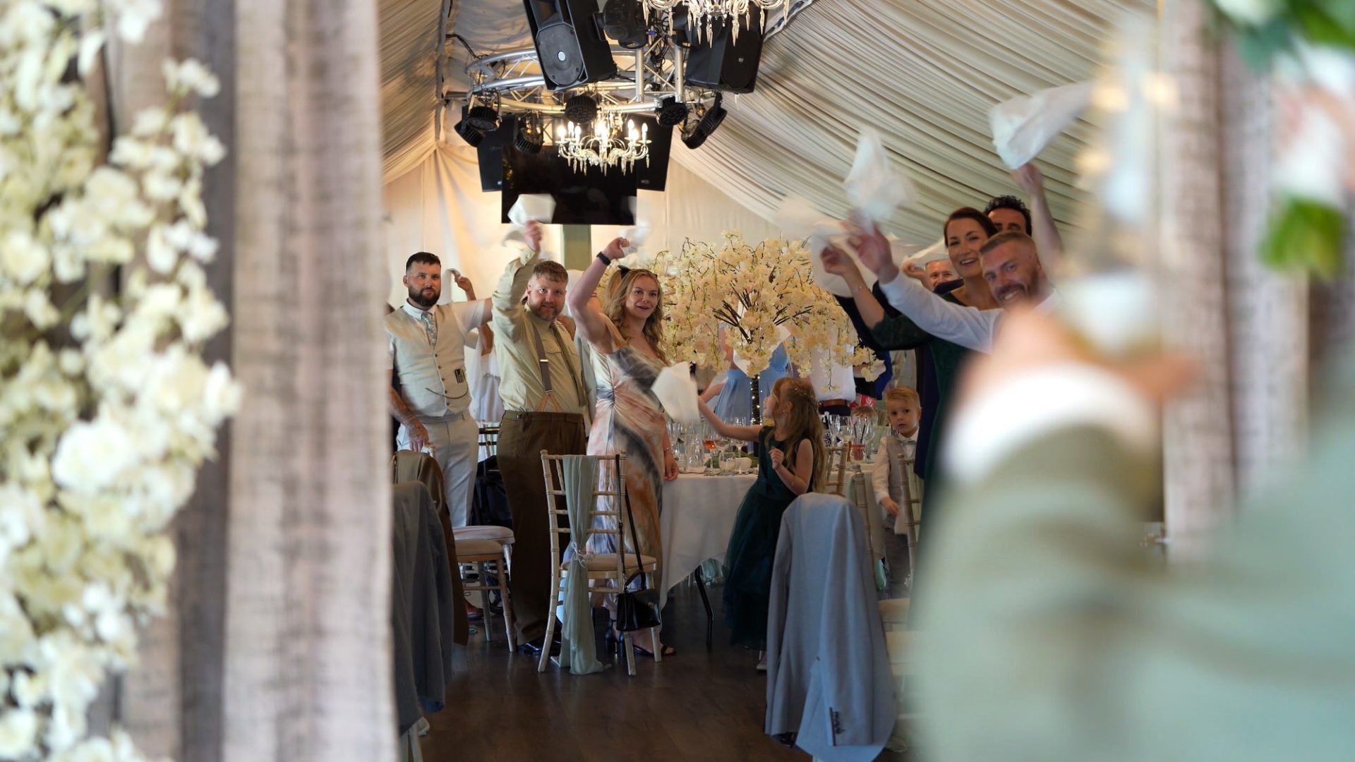 a videographer captures the guests reaction to the couple coming into the reception