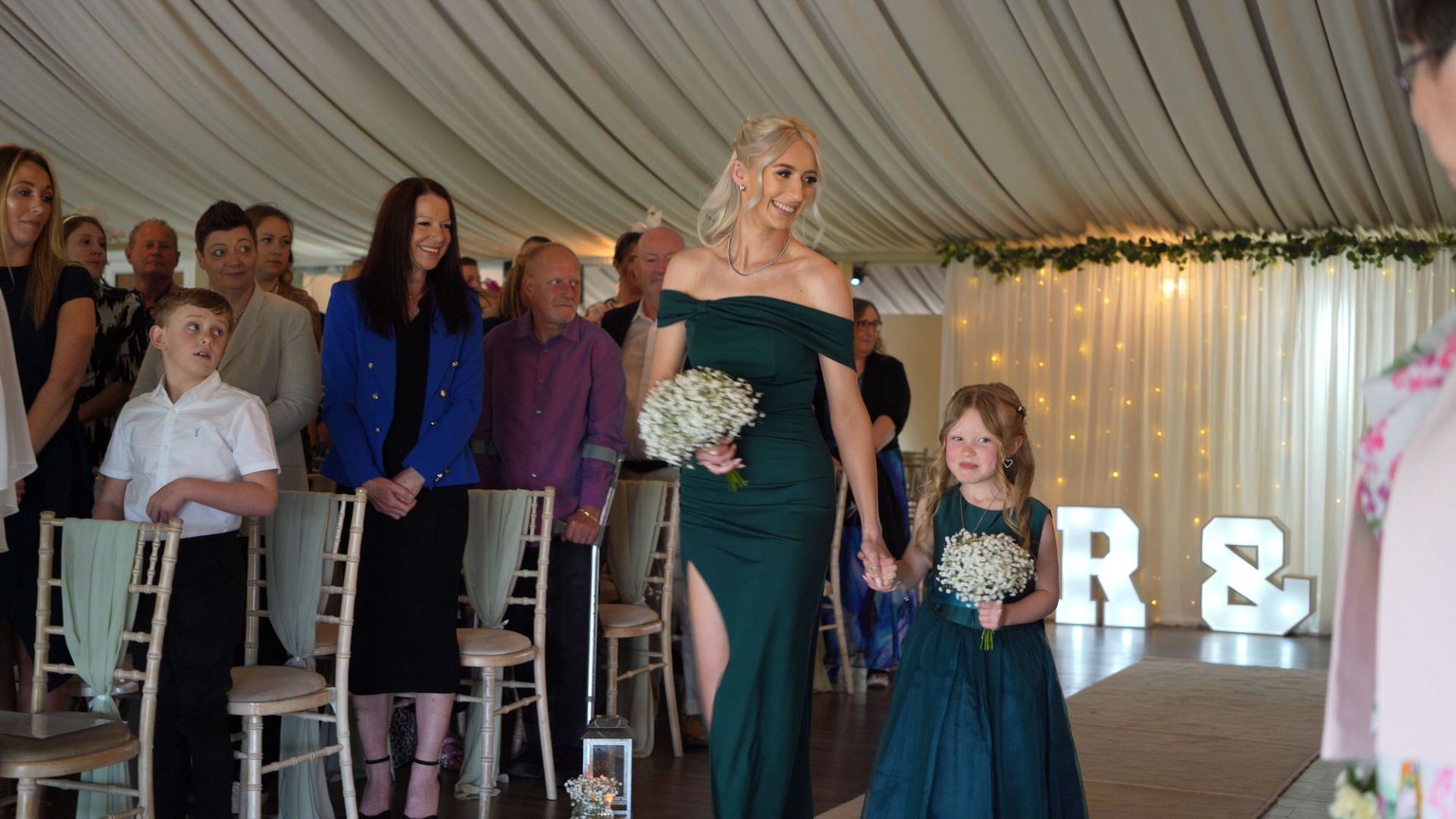 a bridesmaid and flowergirl walk down the aisle at The Moorlands Inn Halifax