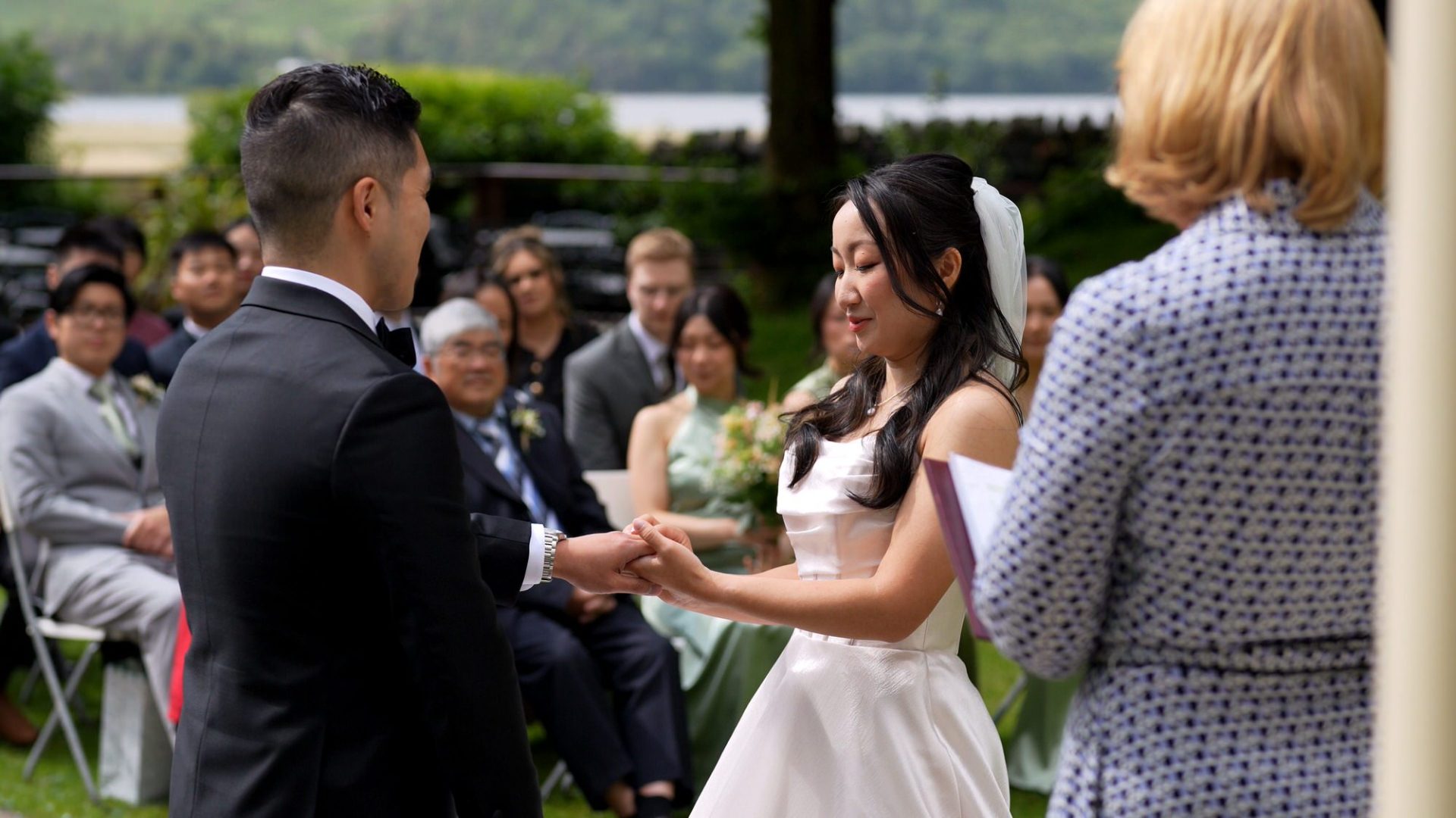 a couple exchange rings during an outdoor ceremony at lodore falls hotel
