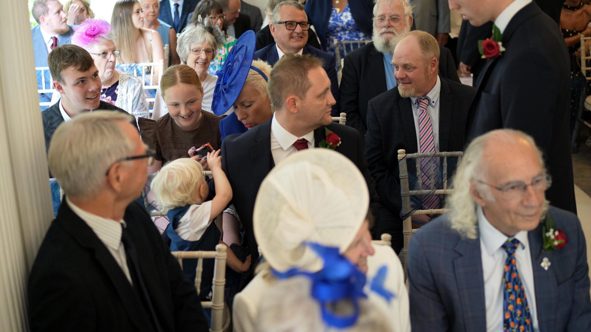 a busy video still of guests chatting during the ceremony at Statham Lodge Hotel in Cheshire