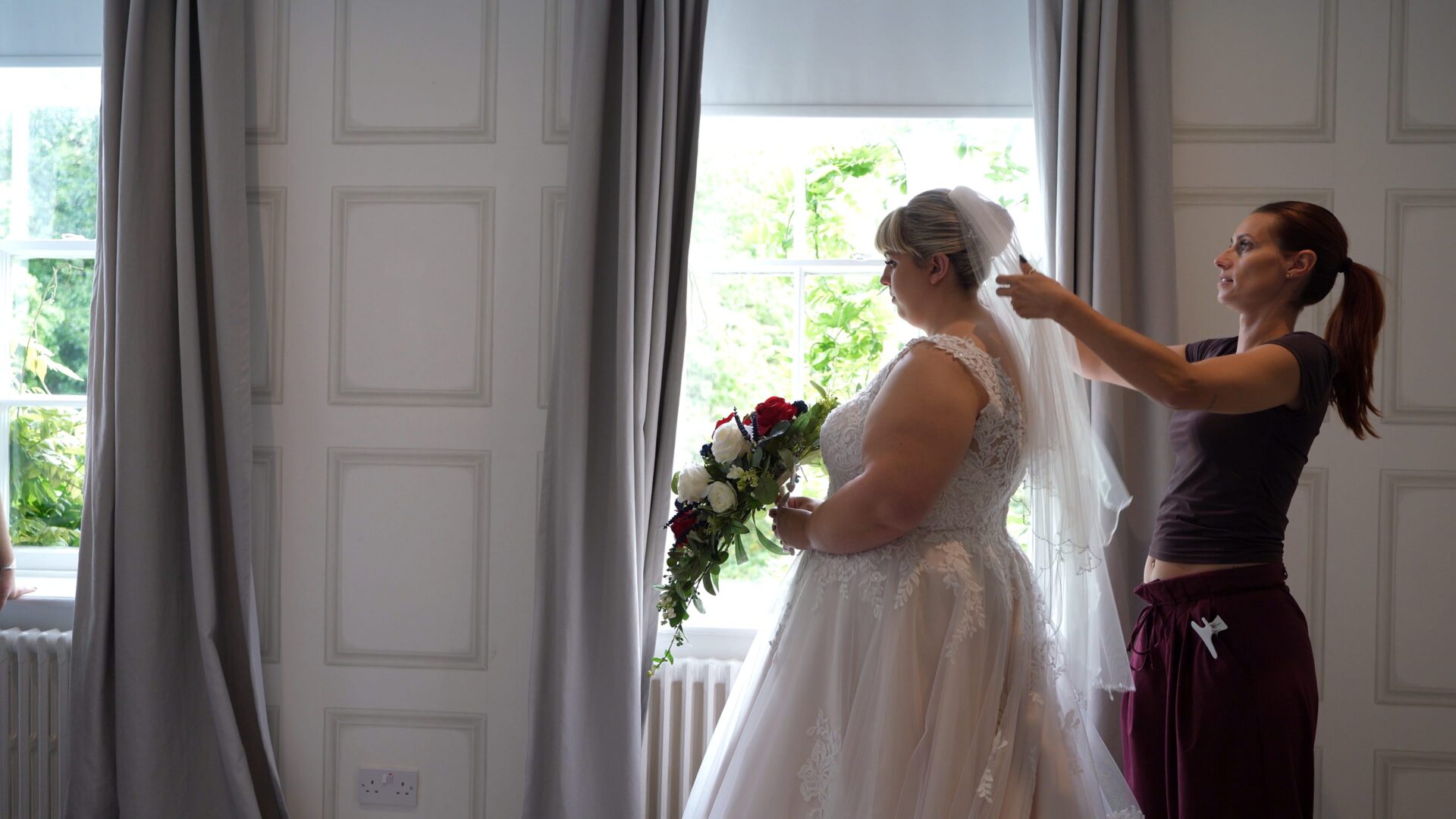 a bride has he veil fitted during morning prep at Statham Lodge Hotel in Cheshire