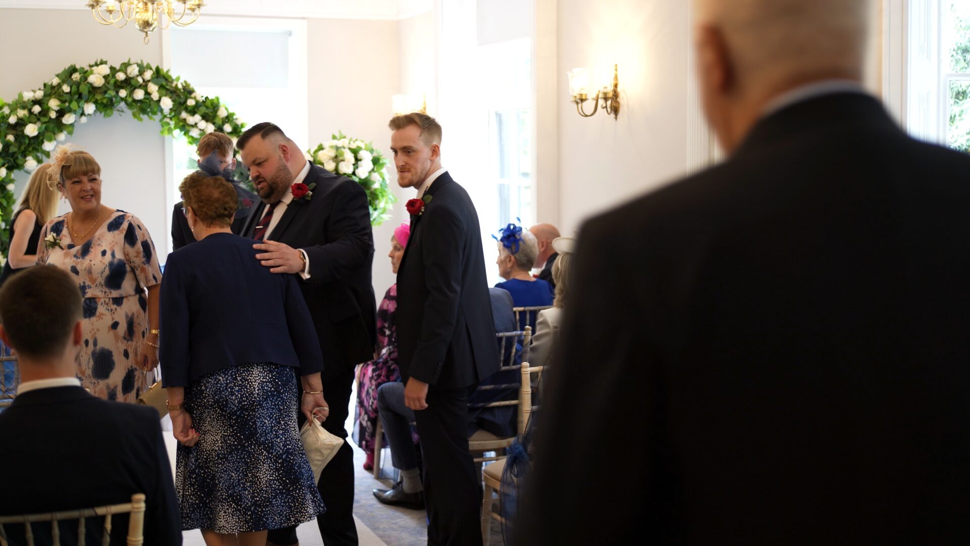 groom and best man welcome guests to their seats at Statham Lodge Hotel in Cheshire
