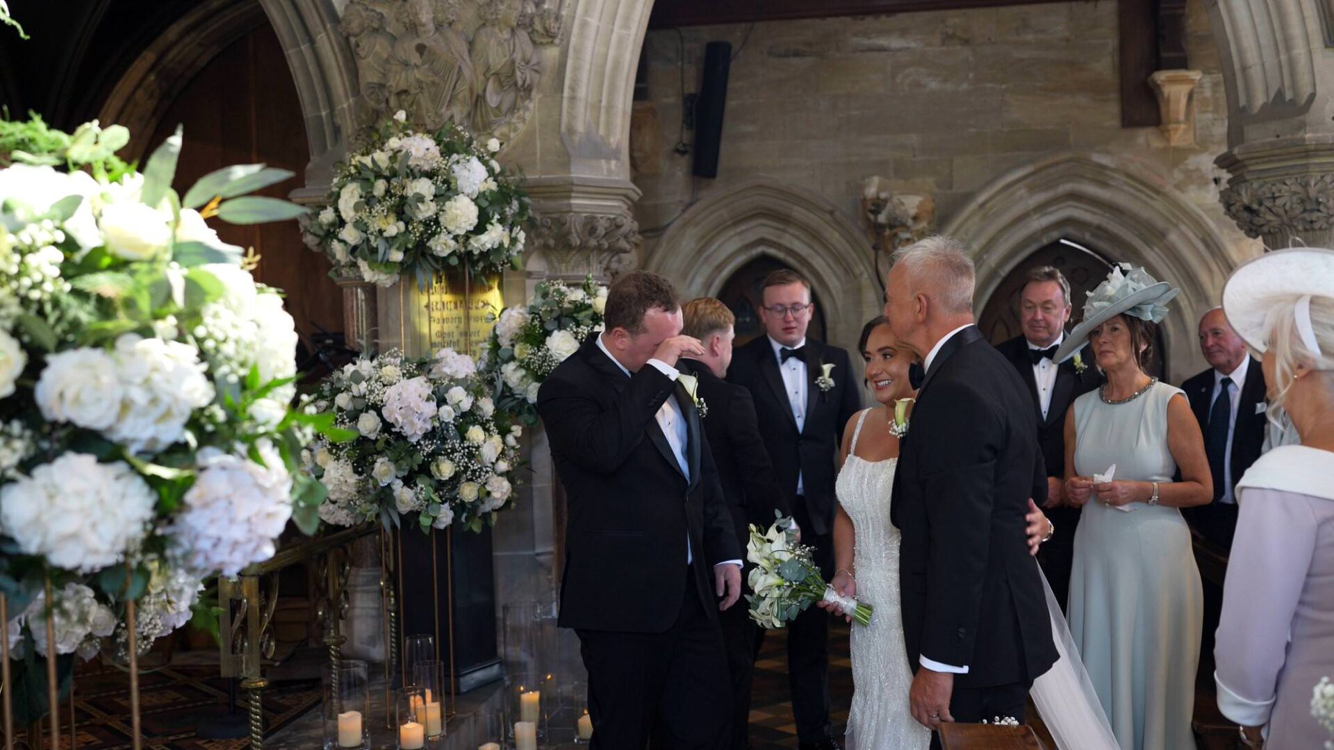 a groom wipes away his tears seeing his bride for the first time