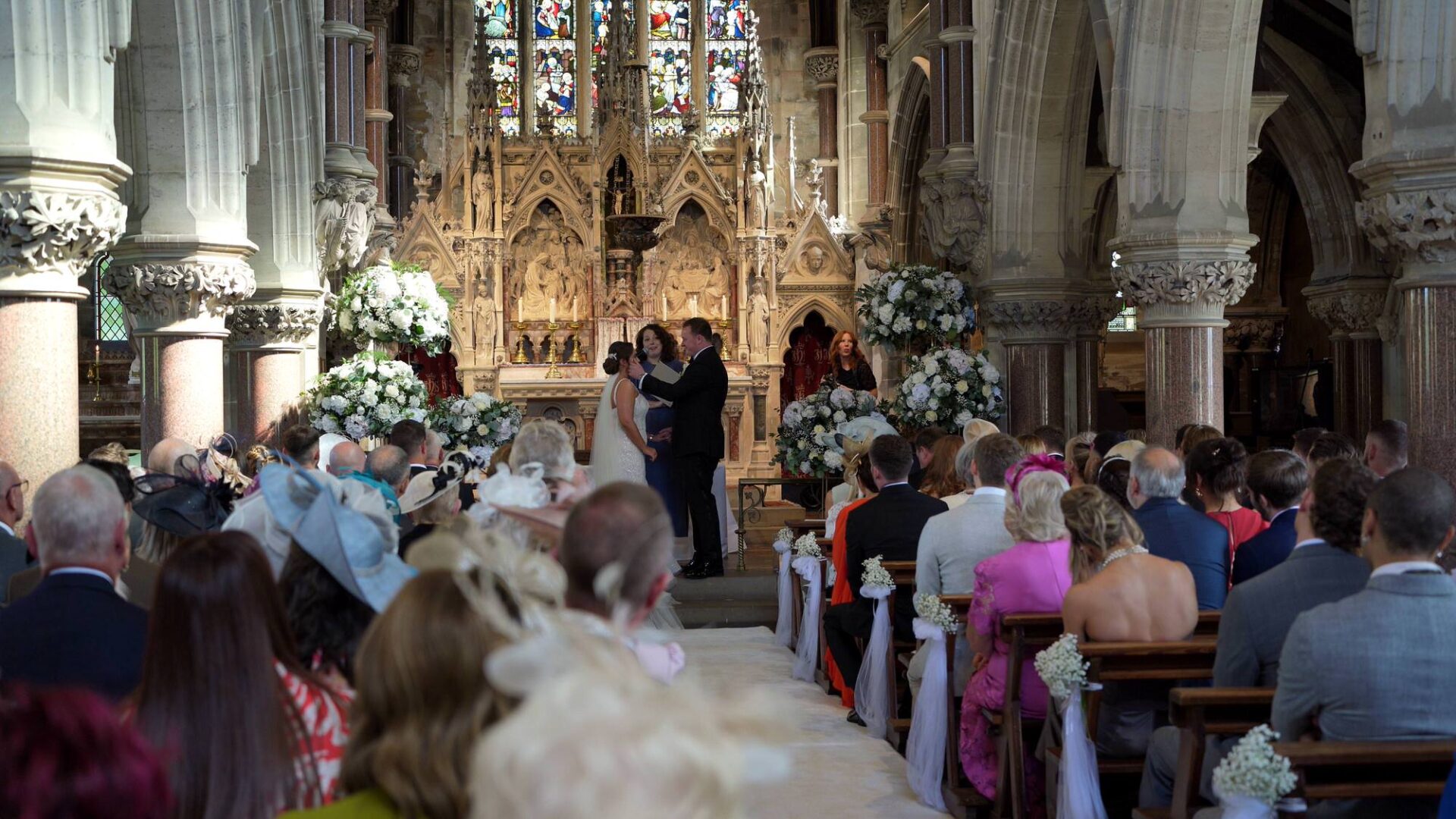 a groom gently wipes a tear from the brides face during their wedding ceremony