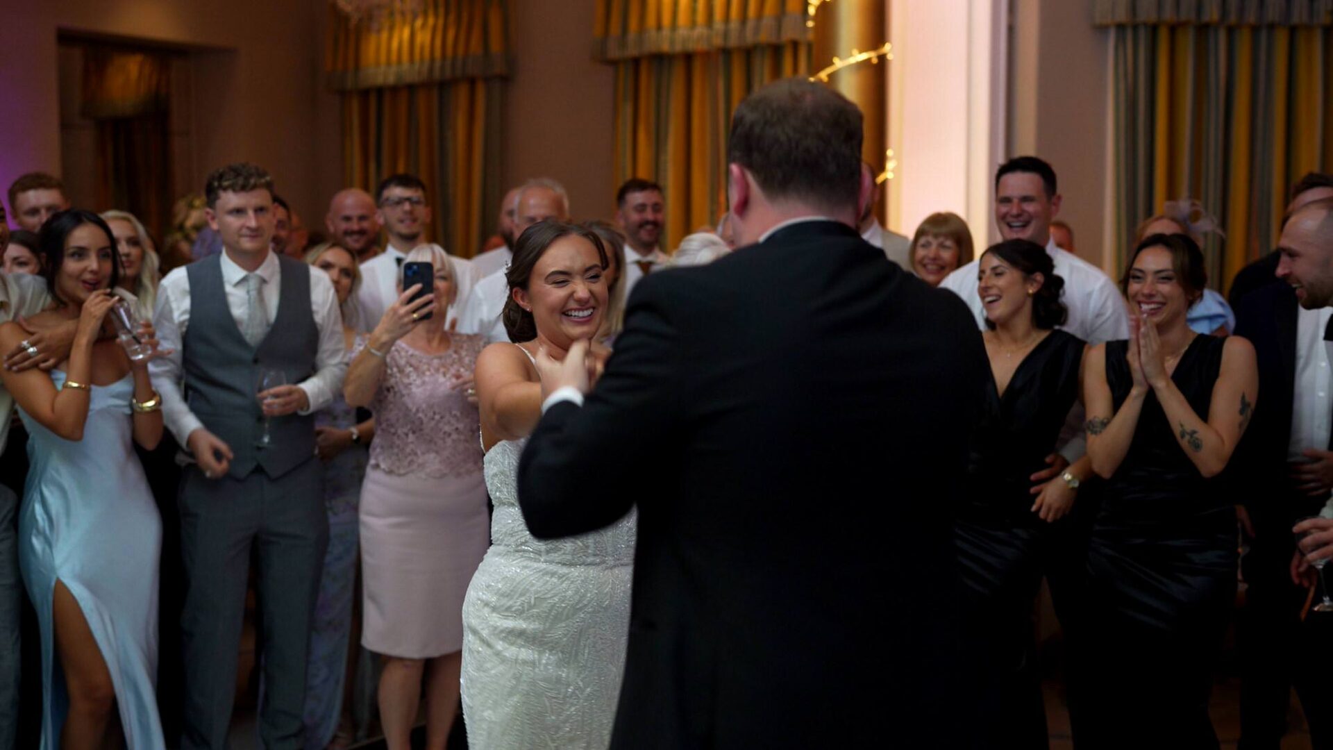 the bride grins as they enjoy their first dance at Rudding Park Harrogate