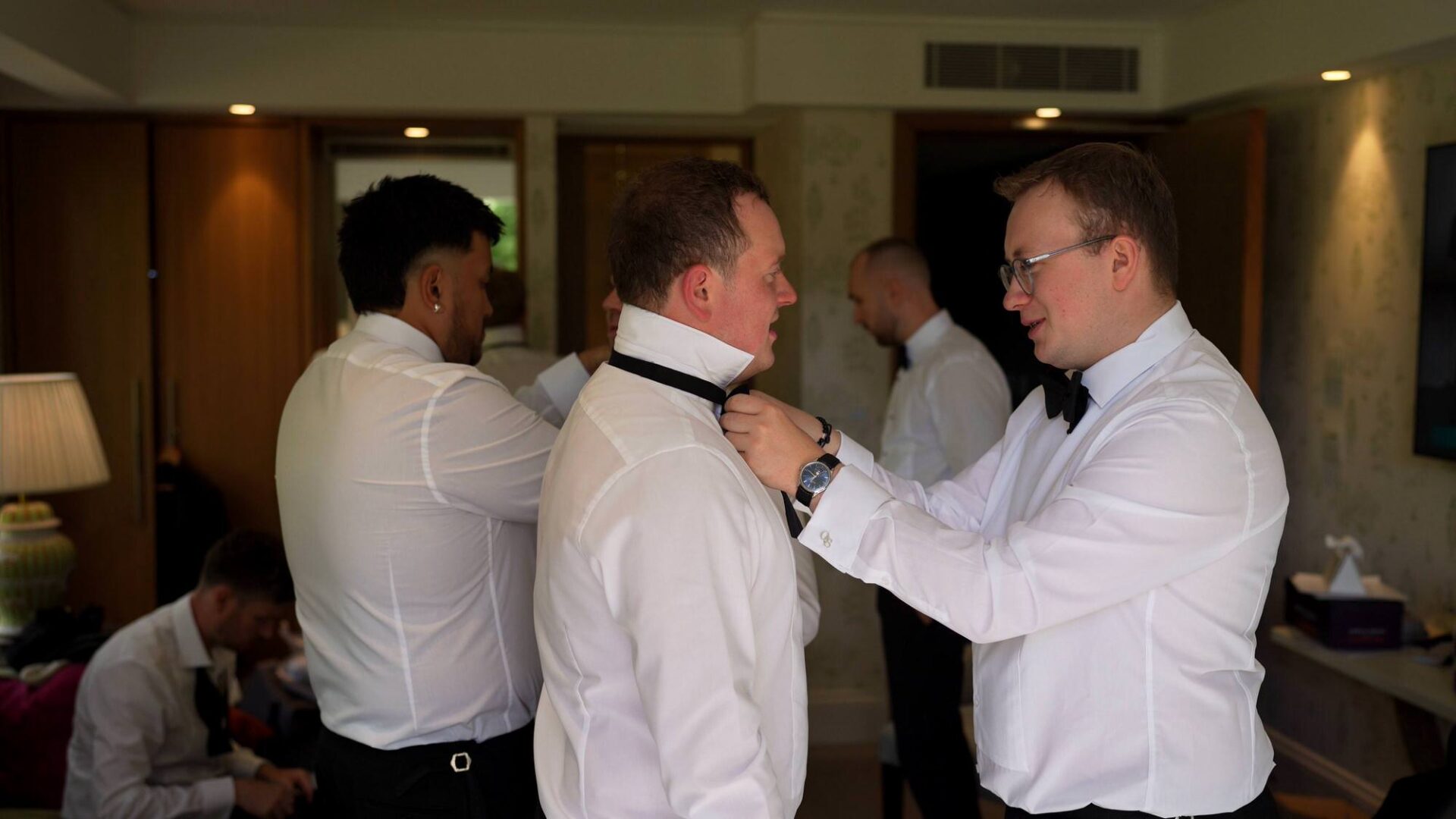 a groom and his groomsmen do their bowties ahead of a ceremony at Rudding Park Harrogate